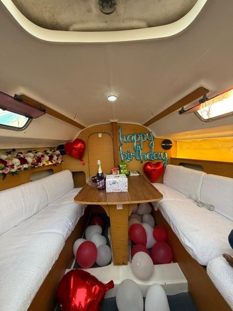 Birthday balloons and cake set up in the sailboat cabin