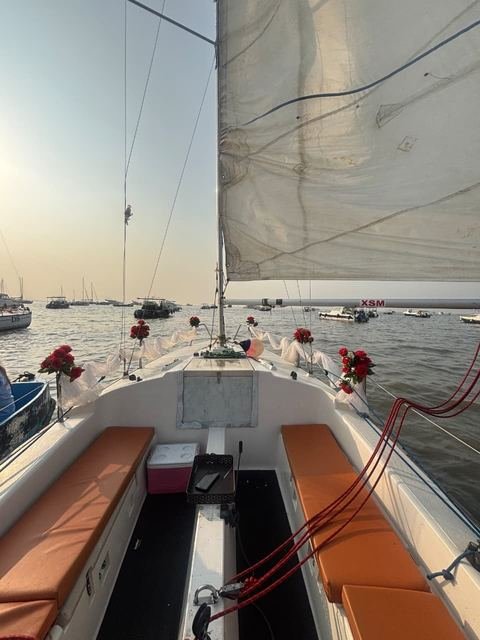 Sunset-lit sailboat decorated with roses for a celebration